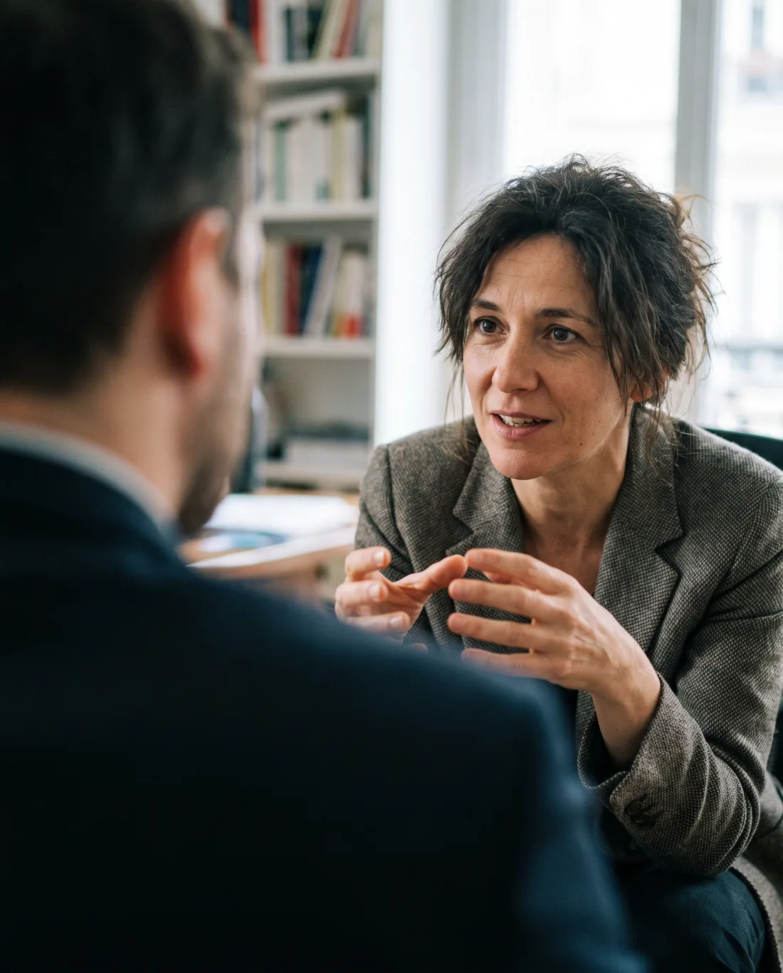 A business coach mid-conversation with a client in a warm studio